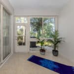 Bright sunroom with large windows and indoor plants, perfect for relaxing or enjoying scenic views.