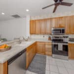 Kitchen interior featuring wooden cabinets, stainless steel appliances, and a spacious layout.