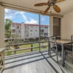 Balcony with outdoor dining area overlooking lush greenery at 220 Santa Maria Street.