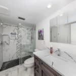Bathroom with marble shower and contemporary fixtures in a stylish home.
