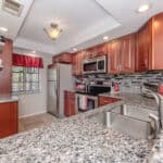 Kitchen with stainless steel appliances and cherry wood cabinets.