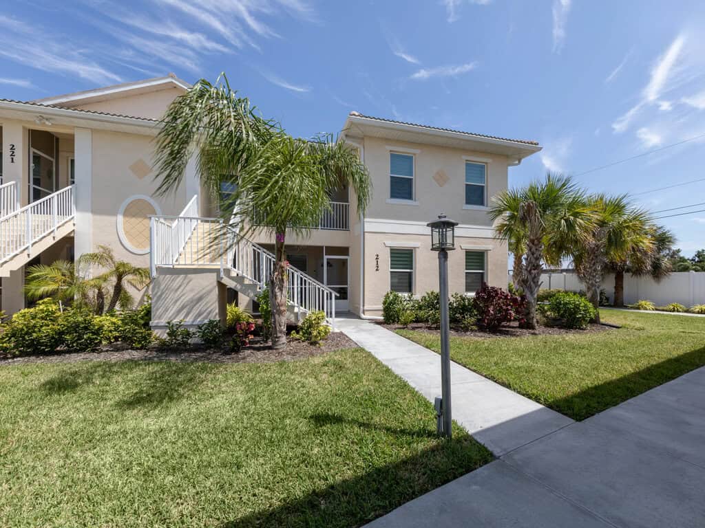 Venice FL townhouse with lush landscaping and palm trees.