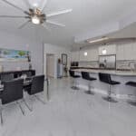 Bright, open-concept kitchen with white cabinets, stainless steel appliances, and a breakfast bar.
