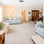 Spacious living area featuring comfortable sofas, a dining table, and vintage furniture.