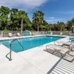 Pool area at 200 Gardens Edge Dr., #212 Venice, Florida, with lush tropical landscaping.