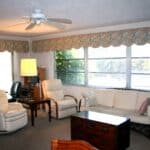 Interior view of a comfortable living room with large windows and classic furniture.