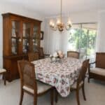 Dining room featuring a chandelier, wooden dining table, and vintage chairs in a cozy home setting.